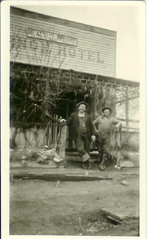 Two men in front of a hotel